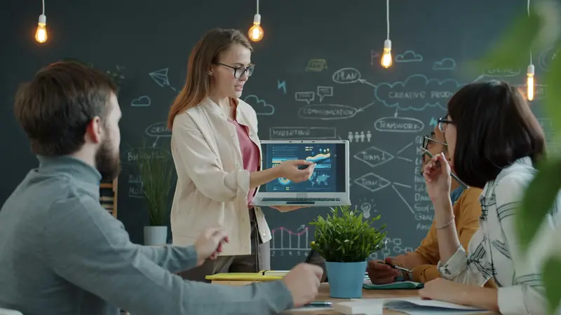 Business conversation at a table with laptops and notebooks